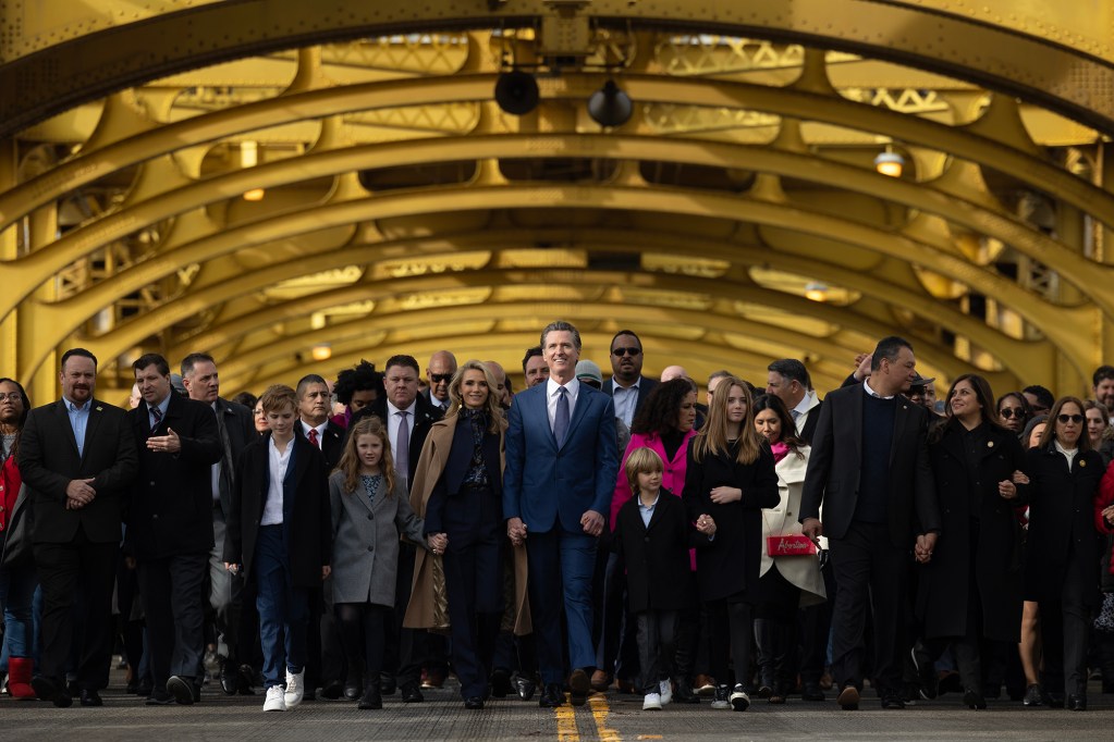 Gov. Gavin Newsom marches with a group of ticketed supporters towards the state Capitol on Jan. 6, 2023. The governor's campaign touted the event as a “March for Democracy”, as it's being held on the two-year anniversary of when supporters of former President Donald Trump stormed the U.S. Capitol. Photo by Miguel Gutierrez Jr., CalMatters